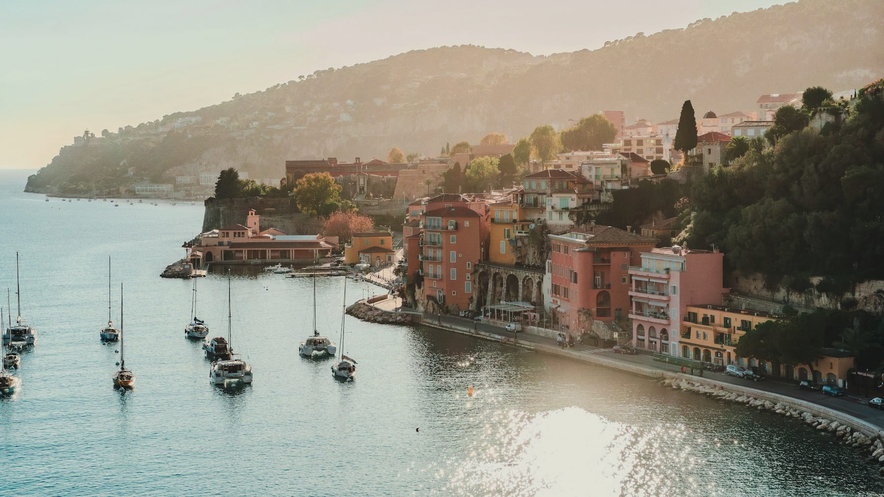 The pastel waterfront of Villefranche-sur-Mer on the Côte d'Azur, boats moored in golden afternoon light.